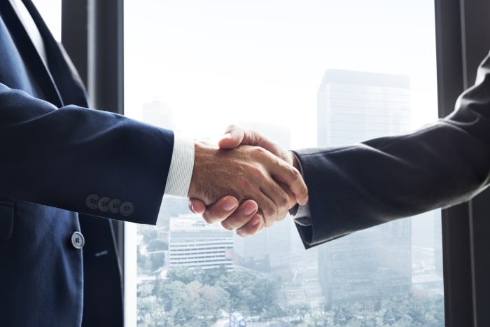 business-handshake-min why headshots are important; people shaking hands