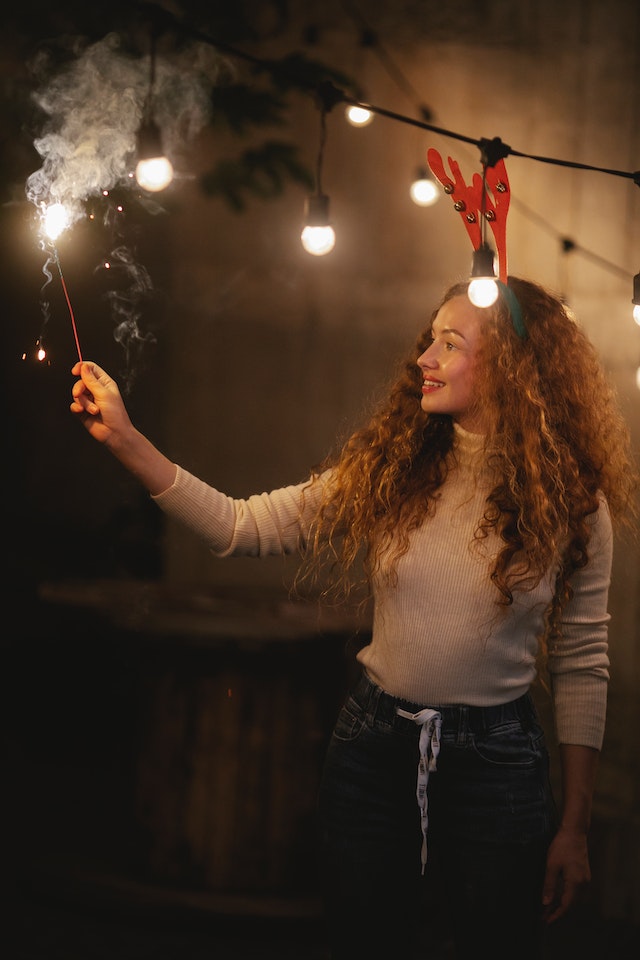 festive photography, a woman in Christmas headband posing with sparklers